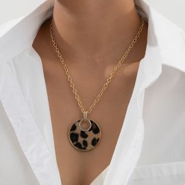 قلادة نسائية عصرية بتصميم فريد، تتميز بسلسلة ذهبية سميكة مع تعليقة دائرية كبيرة بنقشة الفهد، مزينة بحلقة داخلية لامعة