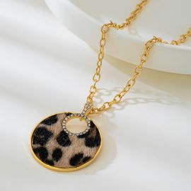 قلادة نسائية عصرية بتصميم فريد، تتميز بسلسلة ذهبية سميكة مع تعليقة دائرية كبيرة بنقشة الفهد، مزينة بحلقة داخلية لامعة