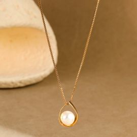 قلادة نسائية أنيقة باللون الذهبي، تتميز بتصميم كلاسيكي على شكل دمعة أو قطرة ماء، بداخلها لؤلؤة لامعة